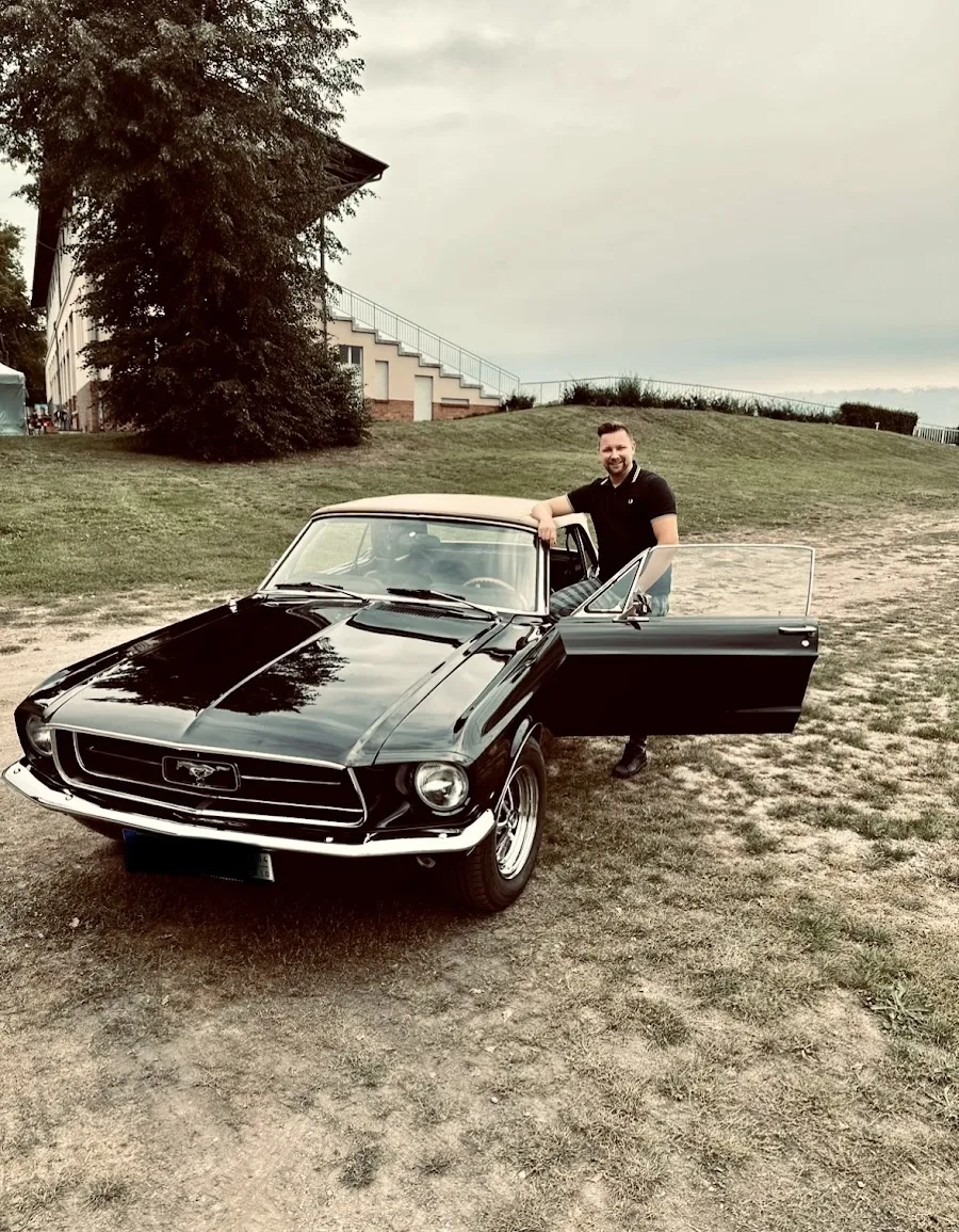 Schwarzer 68er Mustang mit offenen Türen in der Landschaft — Kundenfoto von einer Spritztour